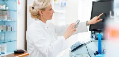 e-notebook header image for case study- woman pharmacist pointing at computer monitor