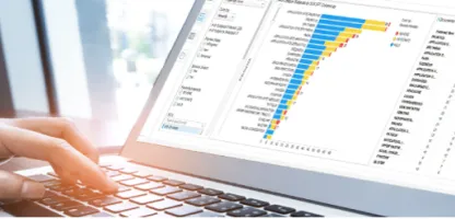 hand on keyboard of lap top with graph on screen