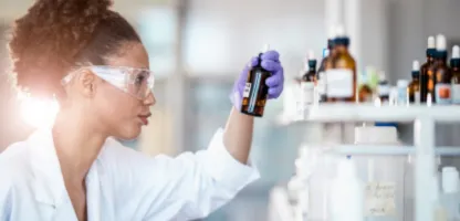 woman scientist with high pony tail looking at inventory bottle