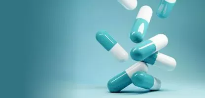 turquoise background with floating pills half white and half turquoise