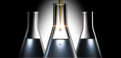 three beakers with liquid and the middle one is bigger - black background