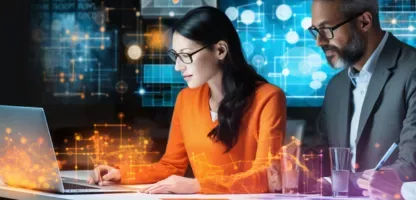 Woman in orange shirt looking at laptop screen, Man in suit next to her looking, and woman in lab coat taking notes