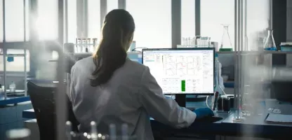 signals research suite flyer header image - woman with pony tail looking at computer screen monitor in lab