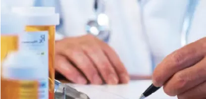 Solutions for pharmacovigilance and drug safety cover image - picture of hands on notebook with prescription bottle in front