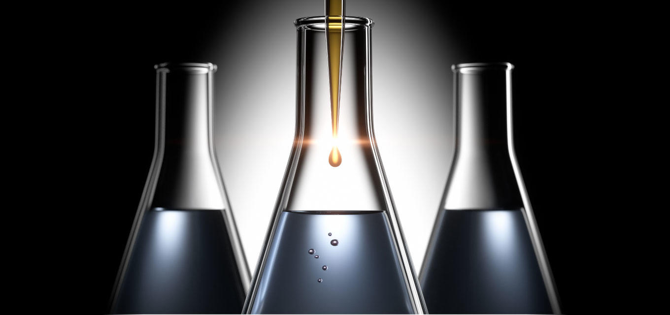 dark background with 3 beakers with liquid and the middle on closer and taller